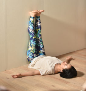 Mujer practica meditacion en postura invertida